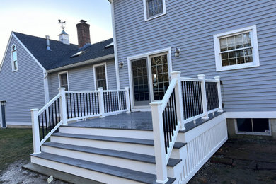 Example of a mid-sized minimalist backyard mixed material railing deck skirting design in Boston