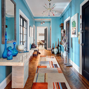 Foto di un corridoio contemporaneo con pareti blu, pavimento in legno massello medio, una porta singola, una porta nera e pavimento arancione