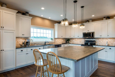 Eat-in kitchen - large traditional l-shaped dark wood floor and brown floor eat-in kitchen idea in Columbus with a farmhouse sink, shaker cabinets, white cabinets, brown backsplash, stone tile backsplash and an island