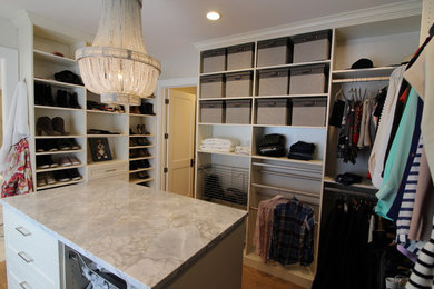 Inspiration for a large transitional women's light wood floor and brown floor walk-in closet remodel in Indianapolis with raised-panel cabinets and beige cabinets