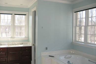 Inspiration for a mid-sized timeless master porcelain tile and beige floor drop-in bathtub remodel in Grand Rapids with raised-panel cabinets, dark wood cabinets, blue walls and an undermount sink