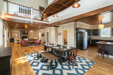 Example of a huge mountain style light wood floor great room design in Boston with beige walls, a standard fireplace and a stone fireplace