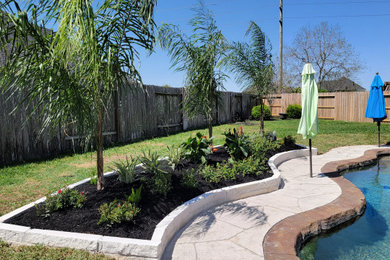 Diseño de jardín tradicional en verano en patio trasero con jardín francés, macetero elevado, adoquines de piedra natural y exposición total al sol