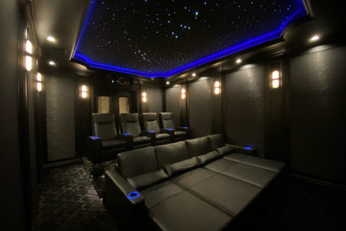 Example of a mid-sized trendy home theater design in Los Angeles with black walls