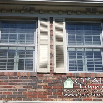 White Andersen 400 Tilt Wash Windows with mixed red toned brick & tan shutters.