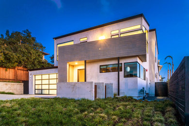 Example of a large minimalist gray two-story stucco flat roof design in San Diego