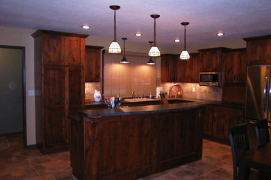 This is an example of a mid-sized traditional l-shaped eat-in kitchen in Wichita with shaker cabinets, medium wood cabinets, ceramic floors, with island, a drop-in sink, beige splashback, ceramic splashback, stainless steel appliances and brown floor.