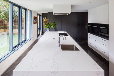 Design ideas for a modern kitchen in Perth with an undermount sink, flat-panel cabinets, white cabinets, quartz benchtops, black appliances, with island and grey benchtop.