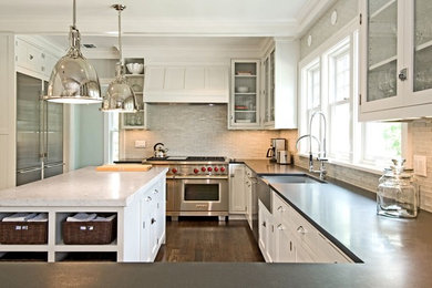 Mid-sized trendy u-shaped dark wood floor and brown floor eat-in kitchen photo in Other with a farmhouse sink, white cabinets, quartzite countertops, white backsplash, glass tile backsplash, stainless steel appliances, an island and shaker cabinets