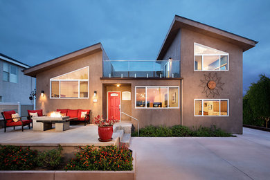 Design ideas for a mid-sized contemporary two-storey concrete beige house exterior in San Diego with a shed roof.