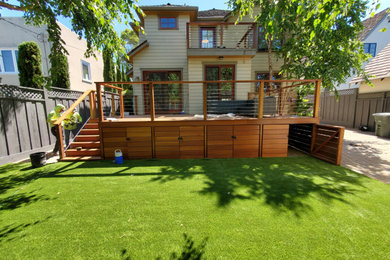 Modelo de terraza planta baja de estilo americano de tamaño medio en patio trasero con privacidad y barandilla de varios materiales