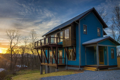 Small trendy three-story mixed siding house exterior photo in Other