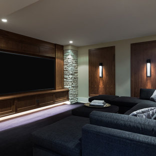 Idées déco pour une grande salle de cinéma contemporaine fermée avec un mur beige, un sol en bois brun, un téléviseur encastré et un sol bleu.