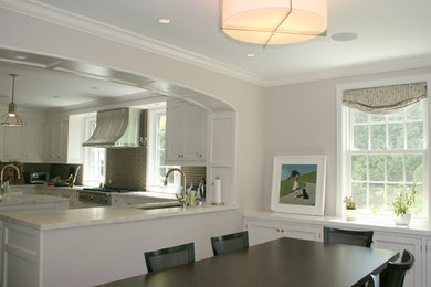 Eat-in kitchen - large transitional u-shaped dark wood floor and brown floor eat-in kitchen idea in New York with a farmhouse sink, marble countertops, beige backsplash, glass tile backsplash, stainless steel appliances, recessed-panel cabinets, white cabinets, an island and white countertops