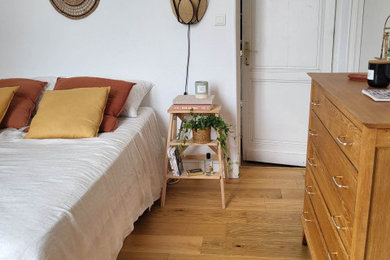Exemple d'une chambre parentale blanche et bois méditerranéenne de taille moyenne avec un mur beige et parquet clair.
