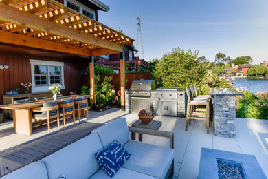 Inspiration for a mid-sized contemporary backyard concrete paver patio kitchen remodel in San Francisco with a pergola