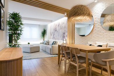 Diseño de salón cerrado y blanco y madera escandinavo de tamaño medio con paredes blancas, suelo laminado, televisor en una esquina, suelo marrón, madera, ladrillo y alfombra