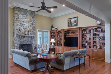 Inspiration for a large timeless open concept medium tone wood floor family room remodel in Philadelphia with yellow walls, a standard fireplace and a stone fireplace