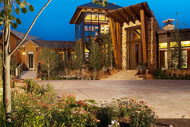 Example of a huge trendy brown three-story stone exterior home design in Denver with a hip roof