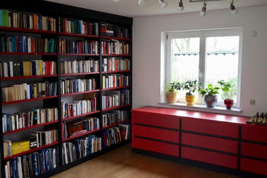 Geräumige, Offene Asiatische Bibliothek mit weißer Wandfarbe, braunem Holzboden, freistehendem TV und braunem Boden in Berlin