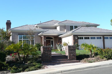 Inspiration for a large transitional beige two-story stucco exterior home remodel in San Diego