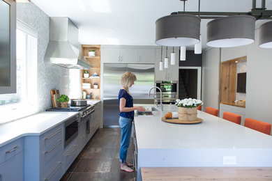 Large trendy u-shaped porcelain tile eat-in kitchen photo in Toronto with an undermount sink, flat-panel cabinets, gray cabinets, quartz countertops, gray backsplash, stone tile backsplash, stainless steel appliances and an island