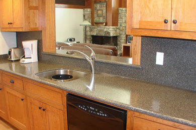 Kitchen - traditional galley kitchen idea in Sacramento with recessed-panel cabinets, granite countertops and gray backsplash