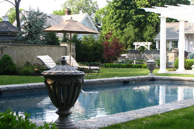 This is an example of a small traditional backyard rectangular lap pool in New York with natural stone pavers.