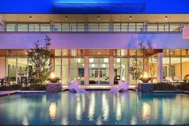 Example of a trendy backyard concrete paver infinity pool design in Miami