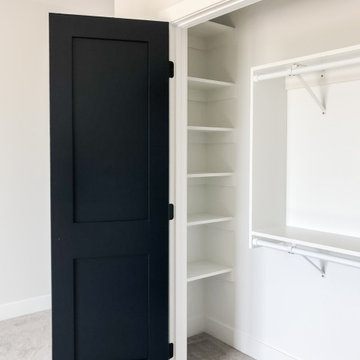 Custom closet shelving with two panel black door