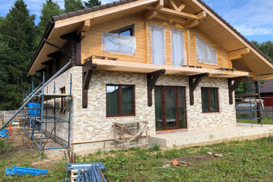 Foto de fachada de casa multicolor clásica pequeña de dos plantas con revestimientos combinados, tejado a dos aguas y tejado de teja de barro