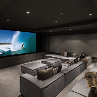 Modern inredning av ett avskild hemmabio, med grå väggar, heltäckningsmatta och grått golv