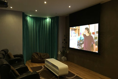 Diseño de cine en casa cerrado minimalista de tamaño medio con paredes marrones y pantalla de proyección