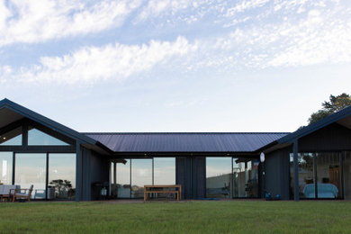 Großes, Einstöckiges Landhaus Einfamilienhaus mit Backsteinfassade, schwarzer Fassadenfarbe, Blechdach und schwarzem Dach in Auckland