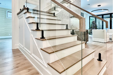 Imagen de escalera recta minimalista de tamaño medio con contrahuellas de metal y barandilla de metal