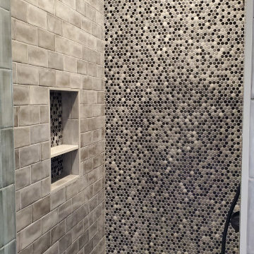 Shower design done with penny rounds on the accent wall and shower floor
