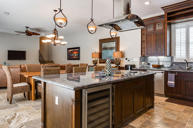 Example of a mid-sized transitional travertine floor eat-in kitchen design in Austin with an undermount sink, granite countertops, stainless steel appliances and an island