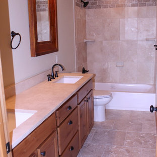 Esempio di una stanza da bagno per bambini stile rurale di medie dimensioni con ante con riquadro incassato, ante marroni, vasca freestanding, vasca/doccia, WC monopezzo, piastrelle beige, piastrelle in travertino, pareti beige, pavimento in travertino, lavabo sottopiano, top in superficie solida, pavimento beige e porta doccia a battente