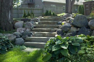 Diseño de jardín rústico en ladera con adoquines de piedra natural