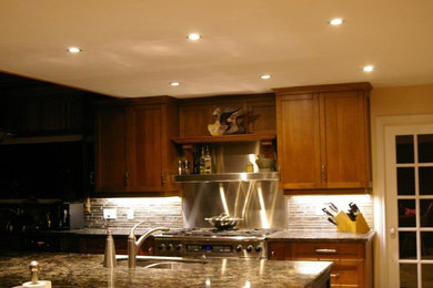 Eat-in kitchen - mid-sized transitional l-shaped eat-in kitchen idea in Toronto with a double-bowl sink, granite countertops, stainless steel appliances, an island, shaker cabinets, medium tone wood cabinets, beige backsplash and stone tile backsplash