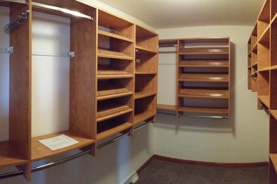 Mid-sized trendy gender-neutral carpeted walk-in closet photo in Milwaukee with open cabinets and medium tone wood cabinets