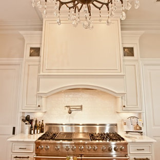 Idéer för att renovera ett stort vintage vit vitt kök, med en undermonterad diskho, luckor med profilerade fronter, vita skåp, marmorbänkskiva, vitt stänkskydd, stänkskydd i tunnelbanekakel, rostfria vitvaror, mellanmörkt trägolv, en köksö och orange golv