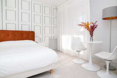 Cette image montre une petite chambre beige et blanche minimaliste avec un sol beige et du papier peint.
