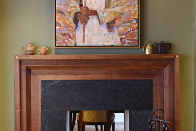 Example of a small classic medium tone wood floor and brown floor living room design in Charleston with green walls, a two-sided fireplace, a wood fireplace surround and a media wall