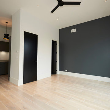 Contemporary Bedroom with Dark Accent Wall and Private Kitchenette