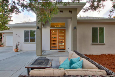 Example of a mid-sized trendy gray one-story stucco house exterior design in Sacramento with a hip roof and a shingle roof