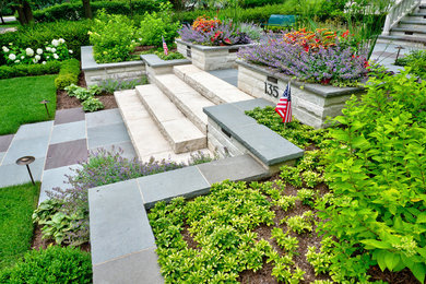 This is an example of a mid-sized contemporary full sun front yard stone landscaping in Chicago for summer.
