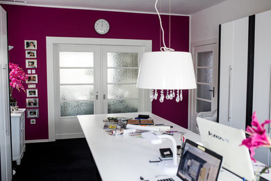Photo of an eclectic home office in Berlin with white walls, carpet, a freestanding desk and black floor.
