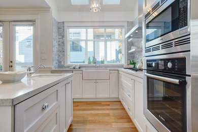 Inspiration for a timeless kitchen remodel in Vancouver with a farmhouse sink, recessed-panel cabinets, white cabinets, gray backsplash and subway tile backsplash