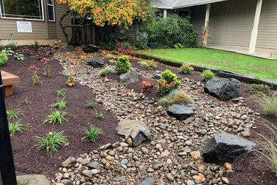 Design ideas for a mid-sized traditional drought-tolerant and rock front yard landscaping in Portland.